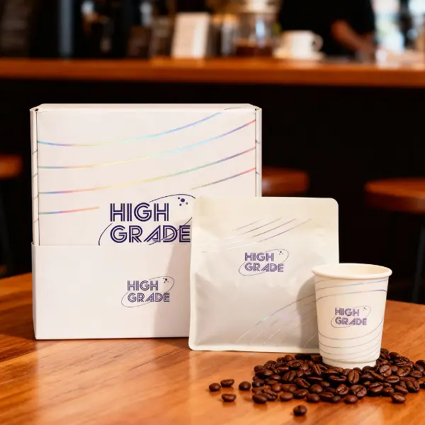 Premium custom brand coffee box showcased with a coffee bag and cup in a cafe environment