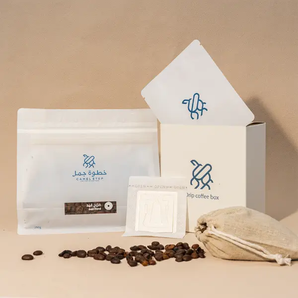 Custom printed paper box with coffee bags, drip coffee pack, and beans in a clean studio setup
